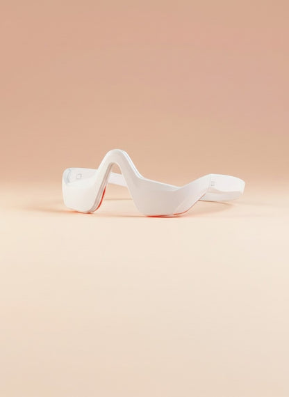 The Glow Lab white EMS eye care device with red light therapy for reducing dark circles and puffiness.